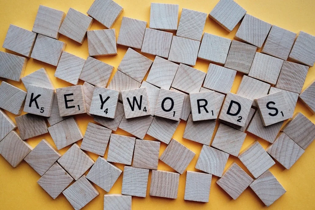 Concept de optimizare SEO și marketing digital reprezentat prin litere din lemn care compun cuvântul KEYWORDS